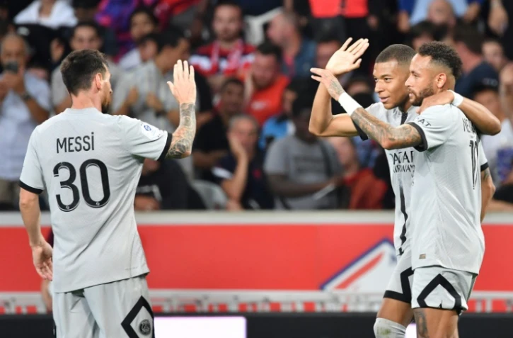 L'attaquant français du Paris SG Kylian Mbappé célèbre un but avec l'attaquant argentin Lionel Messi (à gauche) et l'attaquant brésilien Neymar (tout à droite) lors d'un match de Ligue 1 contre Lille au Stade Pierre-Mauroy de Villeneuve-d'Ascq, le 21 août 2022.