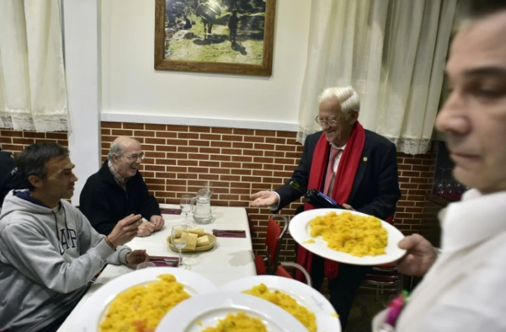 Le prêtre Angel Garcia (à droite) en compagnie de sans-abris pendant leur dîner au restaurant "Robin des Bois" de Madrid, le 1er décembre 2016