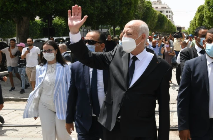 Dans cette photo publiée par la page Facebook officielle de la présidence tunisienne le 1er août 2021, le président Kais Saied (C)  marche lors d'une visite dans le centre de la capitale Tunis