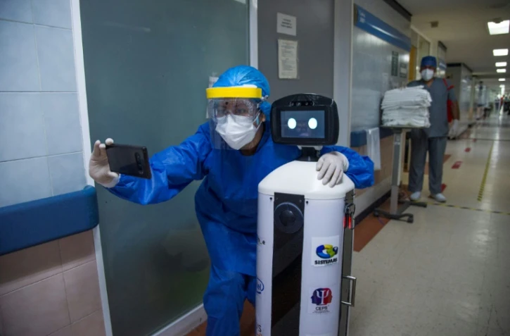 Une soignante prend un selfie avec le petit robot LaLuchy dans un hôpital de Mexico, le 27 août 2020