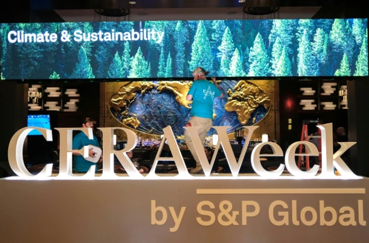 Deux hommes travaillent pour préparer le plus grand rendez-vous mondial des acteurs du pétrole, le 22 mars 2026 à Houston, au Texas