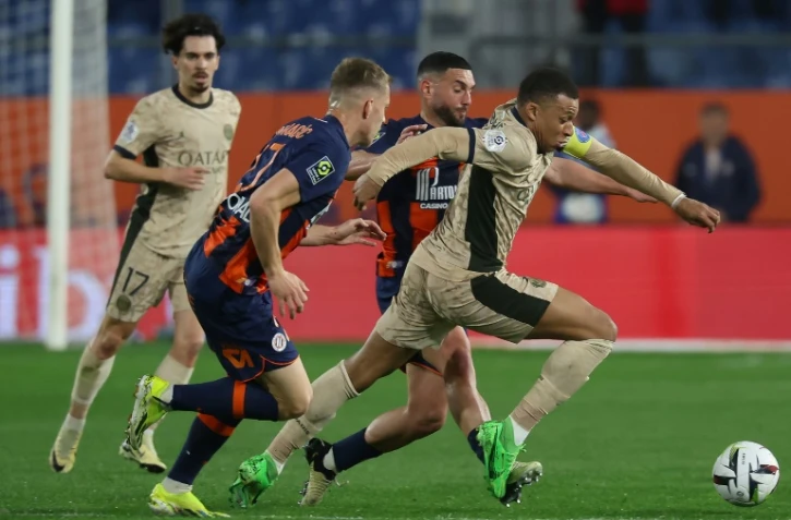 Le capitaine du PSG Kylian Mbappé (d) devance le défenseur de Montpellier Becir Omeragic (c), le 17 mars 2024 à Montpellier