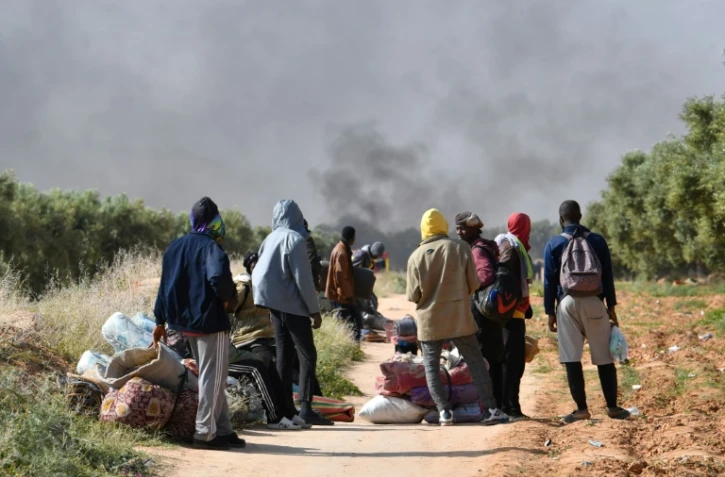 Des migrants d'Afrique subsaharienne observent la destruction de leur camp de fortune, à El Amra en Tunisie le 5 avril 2025