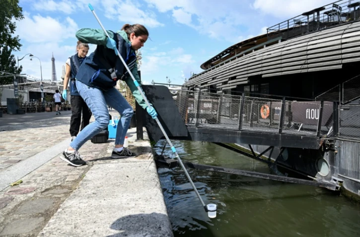 Prélèvement d'un échantillon d'eau le 4 juillet 2023 dans la Seine en vue d'une compétition test de natation pour les JO de Paris-2024, finalement annulée en raison de la pollution
