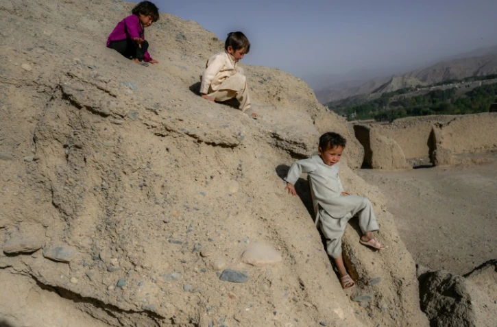 Des enfants de l'ethnie hazara jouent sur une falaise près des grottes où habitent des familles à Bamiyan le 3 octobre 2021