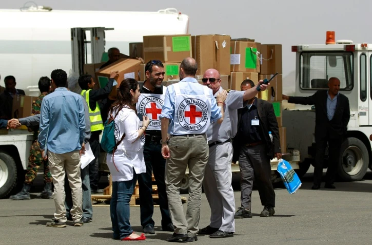 Des employés du Comité international de la Croix-Rouge sur le tarmac de l'aéroport de Sanaa au Yémen, le 10 avril 2015