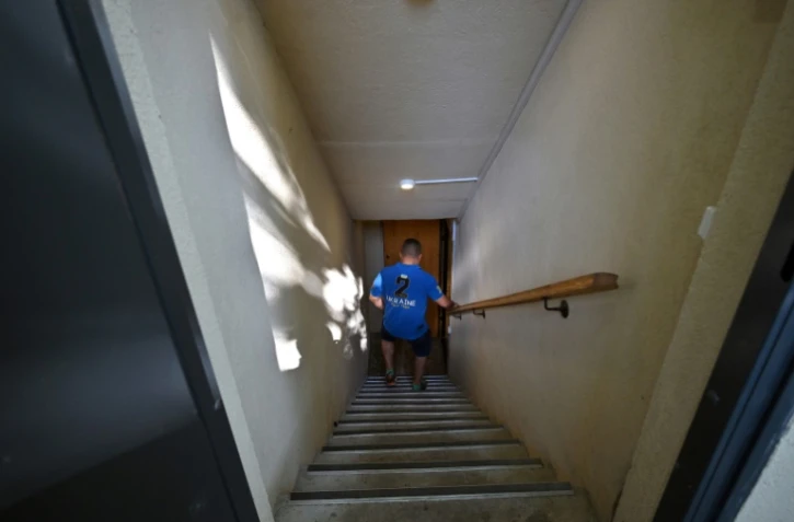 L'avocat Kyrylo Barachkov descend un escalier pour accéder à son bunker, dans la banlieue de Kiev, le 10 juillet 2023 en Ukraine