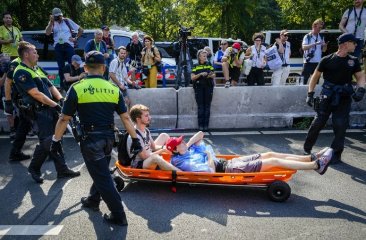Des policiers délogent des activistes du mouvement écologiste Extinction Rebellion qui bloquent une autoroute, le 9 septembre 2023 à La Haye, aux Pays-Bas