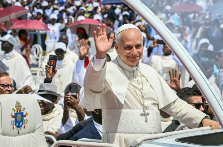 Le pape Léon XIV à bord de la papamobile salue la foule à son arrivée pour célébrer une messe sur l'esplanade de Saurimo, le 20 avril 2026 en Angola