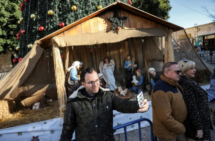 Milad Ayyad, un Palestinien chrétien orthodoxe de la bande de Gaza, devant une crèche sur le parvis de la basilique de la Nativité à Bethléem, en Cisjordanie occupée, le 26 décembre 2021
