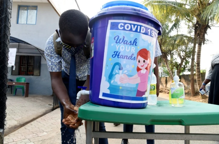 Un étudiant se désinfecte les mains avant la reprise des cours à Magboro (sud-ouest du Nigeria) le 4 août 2020
