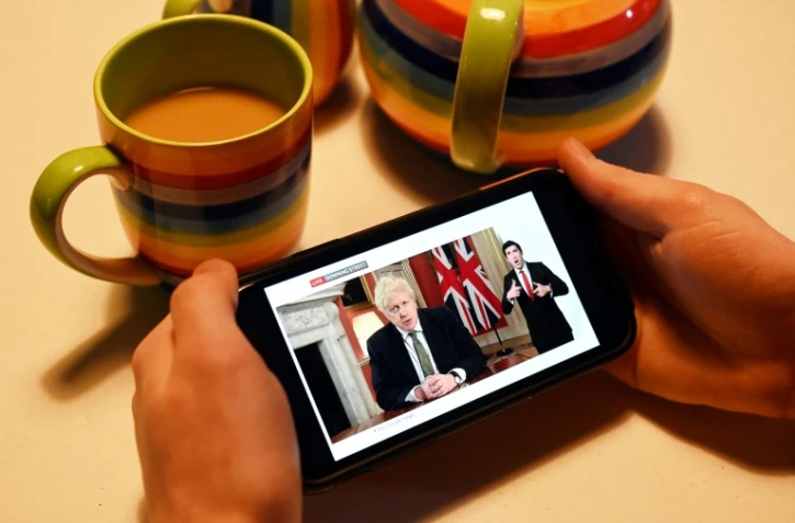 Sur un écran de téléphone portable, le Premier ministre britannique Boris Johnson annonce le nouveau confinement, à Londres, le 4 janvier 2020