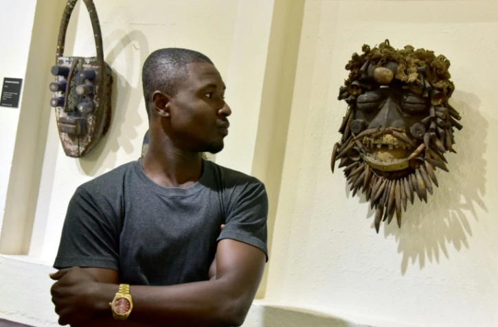 Un visiteur contemple un masque africain au musée des civilisations à Abidjan, le 29 septembre 2017, dans le cadre de l'exposition "Renaissance"