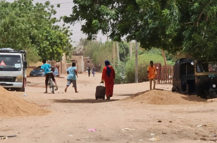 Une femme quitte Khartoum avec sa valise, le 21 juin 2023