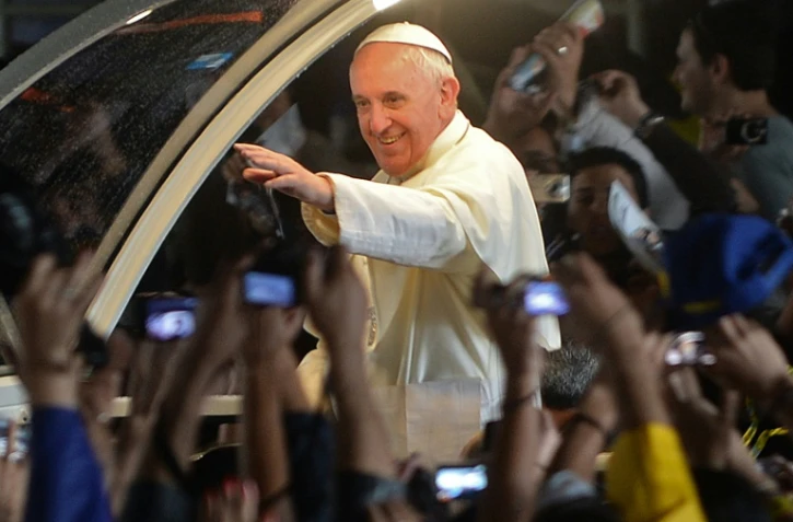 Le pape François salue les fidèles à Rio, depuis sa papamobile, après une messe, le 27 juillet 2013