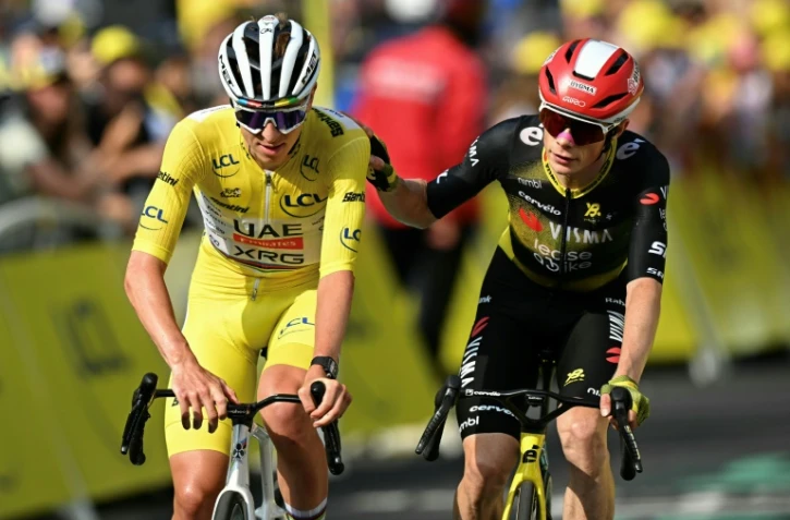 Tadej Pogacar (G) et Jonas Vingegaard (D) franchissent la ligne d'arrivée de la 10e étape du Tour de France, le 14 juillet 2025 au Mont-Dore Puy de Sancy