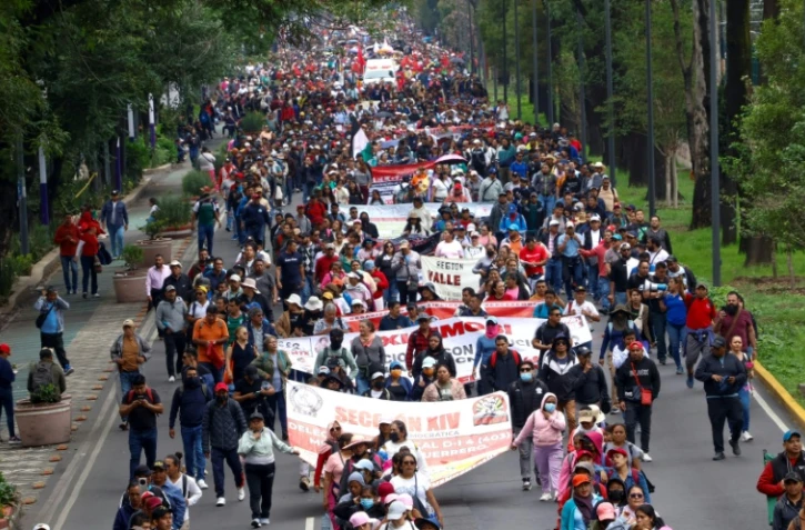 Des enseignants et des élèves marchent vers le stade de Mexico où doivent se dérouler jeudi la cérémonie et le match d'ouverture de la Coupe du monde de football, le 9 juin 2026 au Mexique