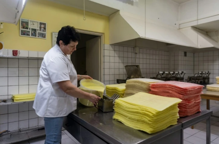 Alicja Slowik prépare la pâte pour la cuisson des "oplatek", feuilles de pain sans levain de Noël, dans la cuisine d'une ferme à Blonie, le 6 décembre 2023 dans le sud de la Pologne