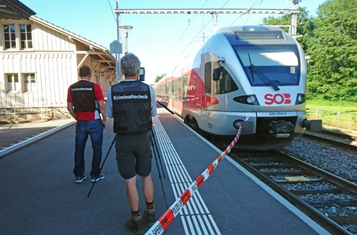 Des policiers aux abords d'un train à la station de Salez (est de la Suisse) après qu'un homme a mis le feu à un wagon et poignardé des passagers, le 13 août 2016