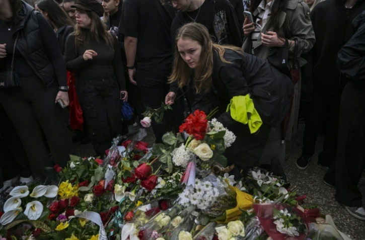 Des étudiants déposent des fleurs lors d'un rassemblement à l'université de Skopje au lendemain d'un incendie qui a ravagé une discothèque bondée à Kocani, le 17 mars 2025 en Macédoine du Nord