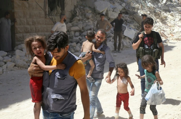 Des Syriens éloignent des enfants d'un quartier d'Alep (Syrie), tenu par des rebelles au régime d'Assad et qui a été la cible de bombardements aériens le 25 juillet 2016