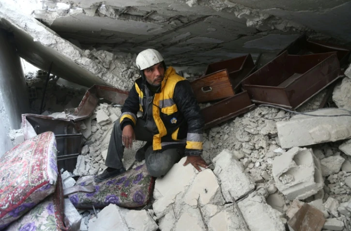 Samir Salim, un secouriste syrien des Casques blancs dans la Ghouta orientale, assis sur les décombre de sa maison à Madira, le 12 février 2018