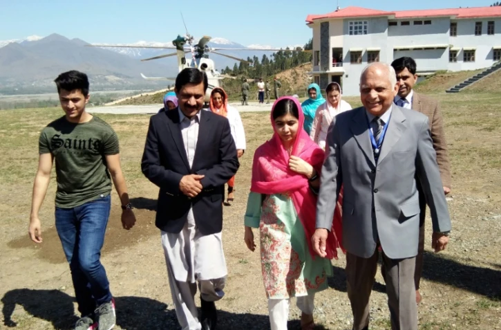 La jeune Pakistanaise prix Nobel de la paix Malala Yousafzai (C), accompagnée de son père Ziauddin Yousafzai (2eG), son frère Atal Yousafzai (G) et du principal de l'école pour garçons Guli Bagh à une quinzaine de km de Mingora, le 31 mars 2018