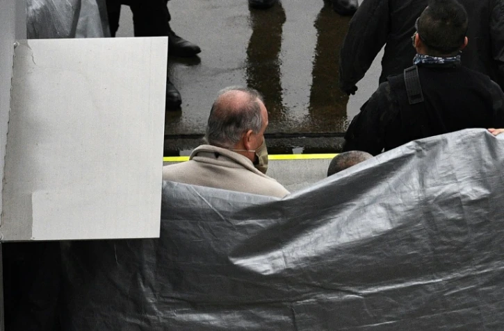 Un homme, supposé être Michael Taylor, accusé d'avoir aidé Carlos Ghosn dans sa fuite, est escorté par des policiers japonais à son arrivée à l'aéroport de Narita, le 2 mars 2021