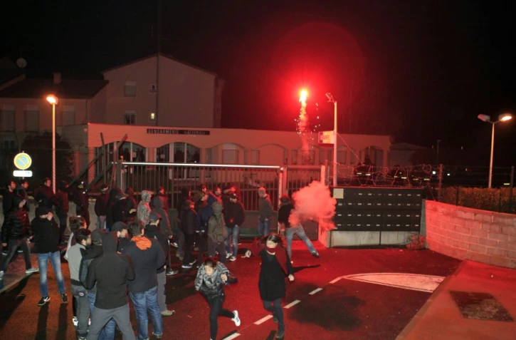 Des manifestants cagoulés ou portant des capuches lancent divers projectiles -pierres, planches, gros pétards - en direction des gendarmes mobiles venus de Bastia, le 15 février 2016 à Corte