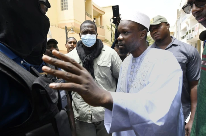 Le leader de l'opposition Ousmane Sonko parle avec des policiers devant chez lui, le 17 juin 2022 à Dakar, au Sénégal