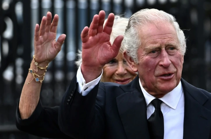 Le roi Charles III et la reine consort Camilla saluent la foule à leur arrivée au palais de Buckingham, le 9 septembre 2022 à Londres