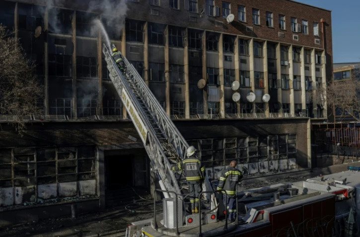 Les pompiers à l'oeuvre pour éteindre un incendie meurtrier dans un immeuble de  Johannesburg le 31 août 2023