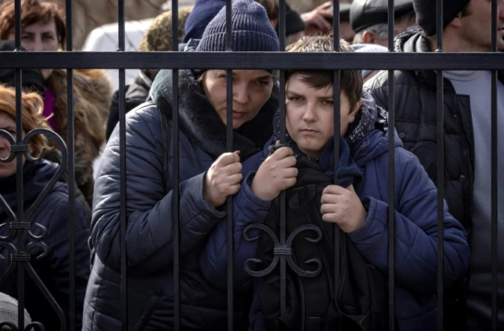 Des habitants attendent une distribution de nourriture devant une église à Trostyanets en Ukraine le 29 mars 2022