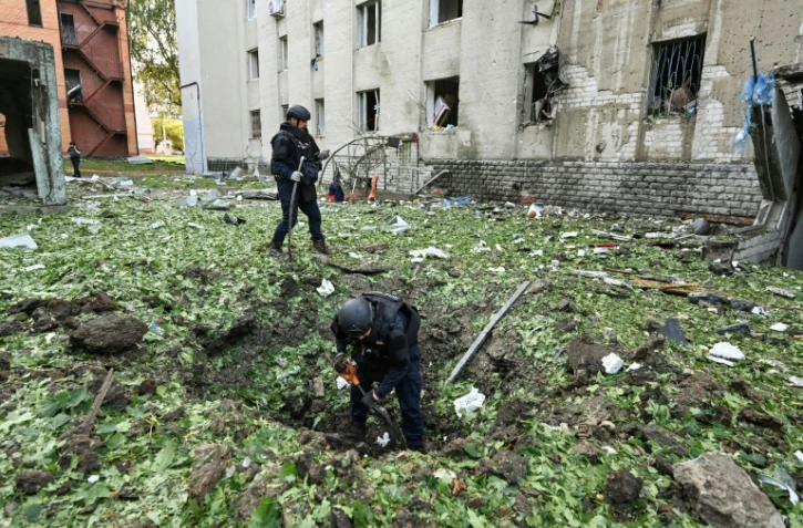 Des policiers dégagent les débris causés par une frappe de drone russe près d’un immeuble résidentiel endommagé à Kharkiv en Ukraine, le 7 juillet 2025