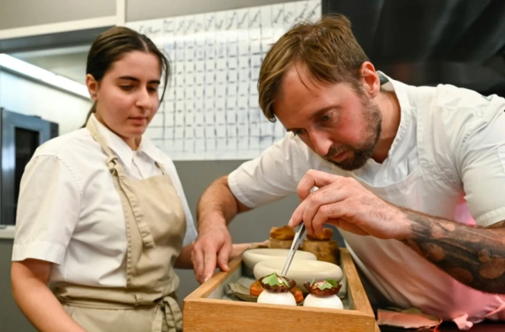 Le chef Loïc Villemin (D) confectionne un plat dans sa cuisine du restaurant "Toya", à Faulquemont, en Moselle, le 4 novembre 2021