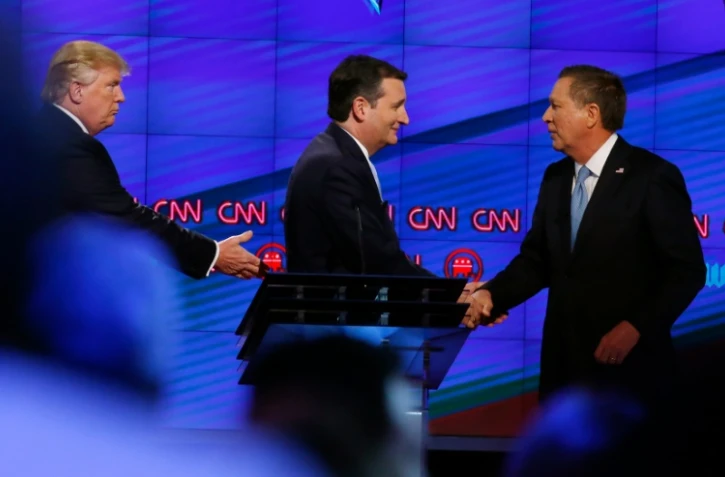 Donald Trump (g), le sénateur du Texas Ted Cruz (c), et le gouverneur de l'Ohio, John Kasich, se serrent la main après un débat sur la chaîne CNN, à Miami, en Floride, le 10 mars 2016