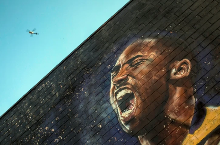 Un hélicoptère survole une peinture murale consacrée à Kobe Bryant, le 26 janvier 2020 dans le centre de Los Angeles