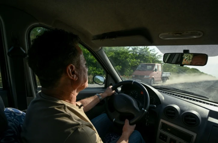 Le médecin Jorj Cristea au volant de sa vieille Dacia, sur la route pour se rendre au village de Chilia Veche, le 9 juin 2023 en Roumanie