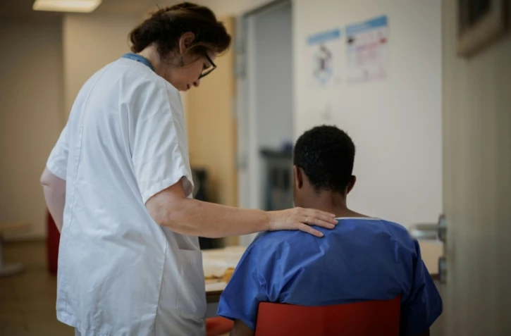 Une aide-soignante encourage un patient pour qu'il s'alimente en salle des repas du Centre renforcé d'urgences psychiatriques de l'hôpital Delafontaine à Saint-Denis en Seine-Saint-Denis le 17 juin 2026