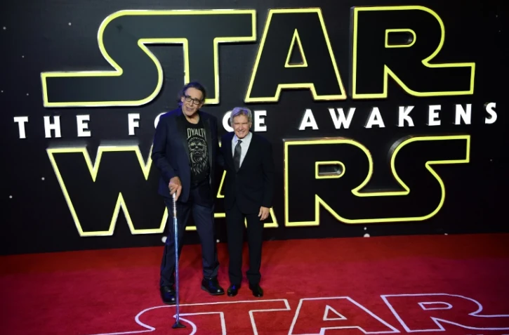 Peter Mayhew (gauche), qui incarnait le personnage de Chewbacca, aux côtés de l'acteur américain Harrison Ford qui joue Han Solo dans la saga Star Wars, le 16 décembre 2015, pour la présentation à Londres du "Réveil de la Force"