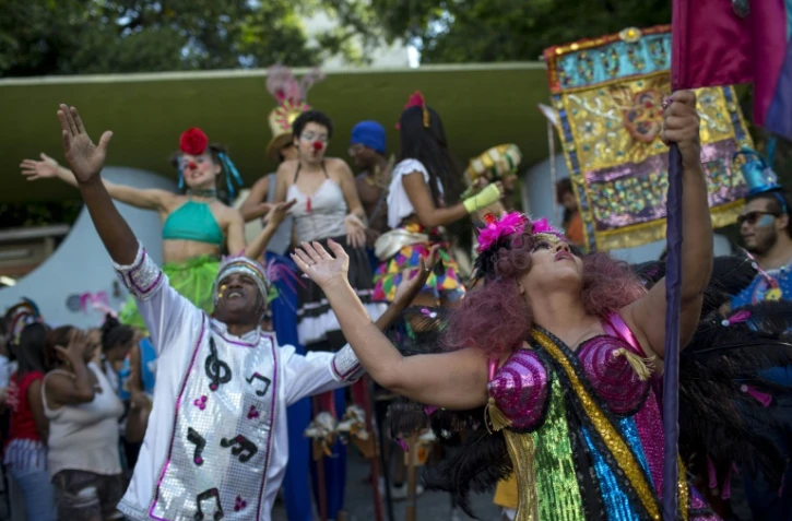 Des danseurs lèvent les bras au ciel au sein du cortège "Loucura suburbana", pendant le carnaval de Rio, le 8 février 2018