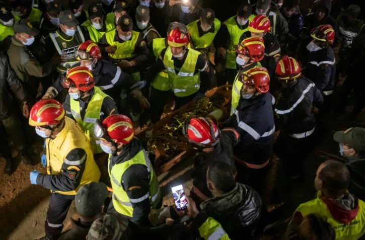 Des sauveteurs transportent le corps du petit Rayan, retrouvé mort le 5 février 2022, cinq jours après être accidentellement tombé dans un puits à Ighrane, dans le nord du royaume