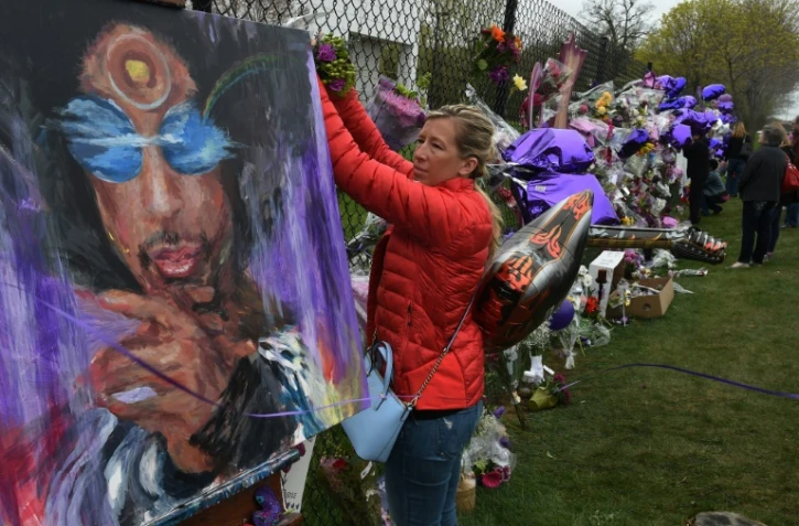 Une fan attache des fleurs en hommage à Prince à Minneapolis, le 22 avril 2016