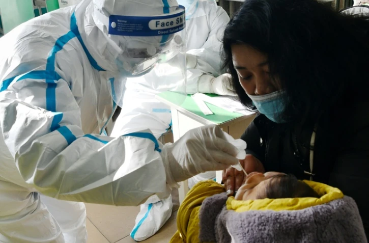 Un soignant prend un échantillon de sang d'un enfant le 7 janvier 2021 à Shijiazhaung, en Chine