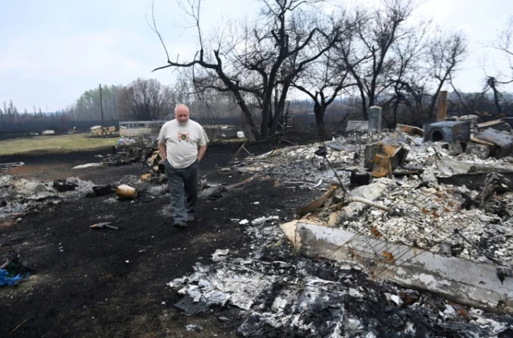 Adam Norris, un habitant, regarde les restes de sa maison détruite dans un incendie à Drayton, dans la province canadienne de l'Alberta, lundi 8 mai 2023
