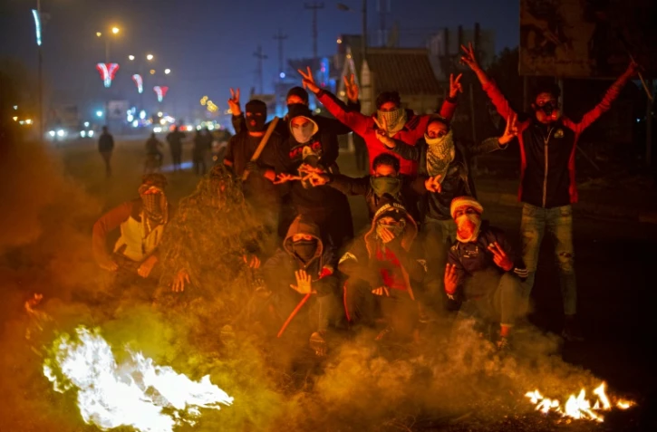 Des Irakiens manifestent près de pneus enflammés pour barrer une route à Bassora, dans le sud de l'Irak, le 24 décembre 2019