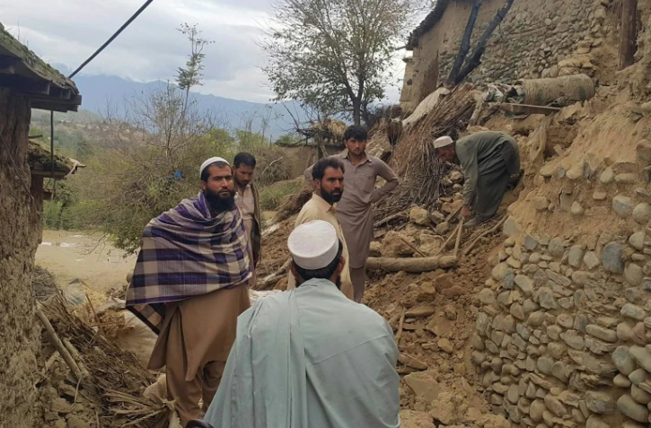 Des pakistanais se rassemblent près des décombres de plusieurs maisons, après un puissant séisme à Bajaur, au Pakistan, le 26 octobre 2015