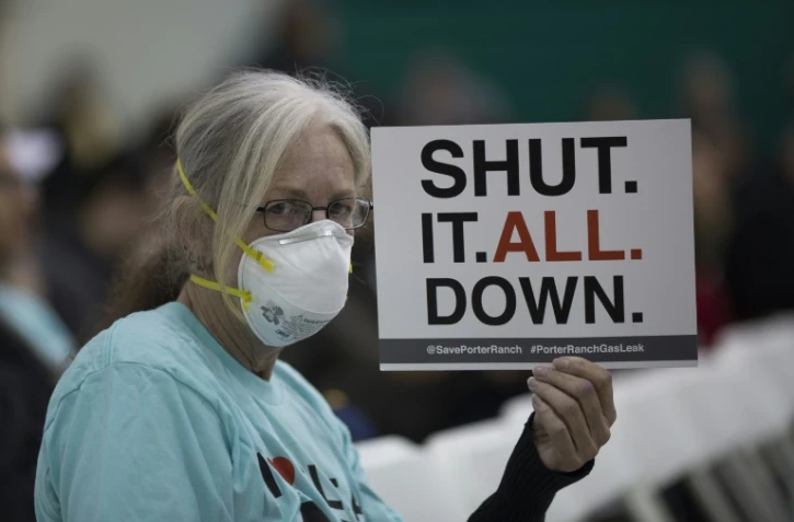 Une femme tient une pancarte pendant un rassemblement au sujet d'une fuite de gaz massive, à Granada Hills, près de Porter Ranch, en Californie, le 16 janvier 2016