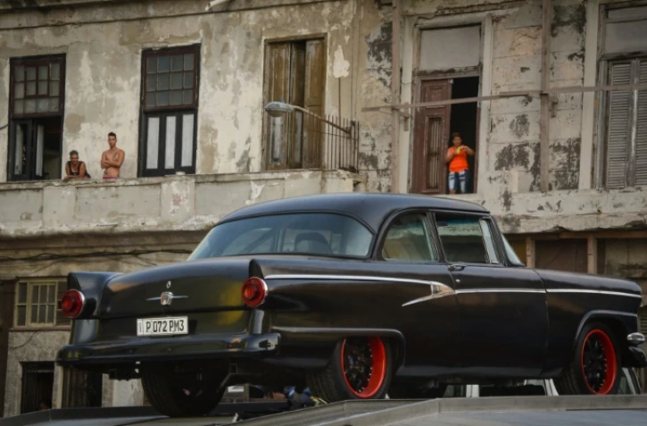 Des Cubains regardent des voitures "vintage" filmées pour la série "Fast & Furious", le 28 avril 2016 à La Havane