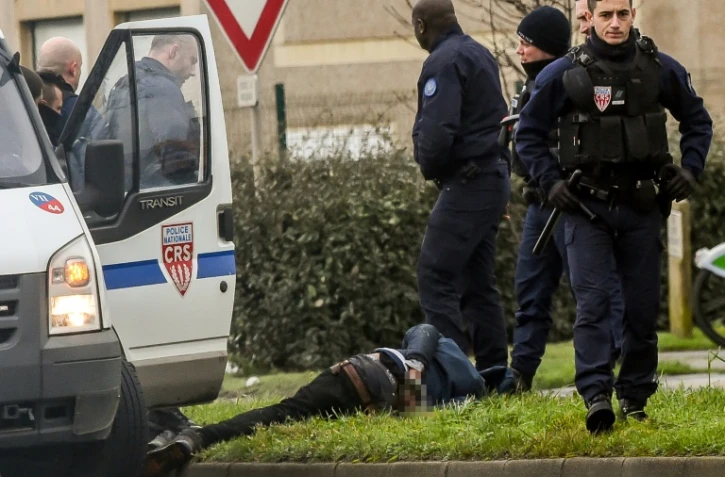 Des policiers viennent d'arrêter un migrant le 25 janvier 2018 à Calais